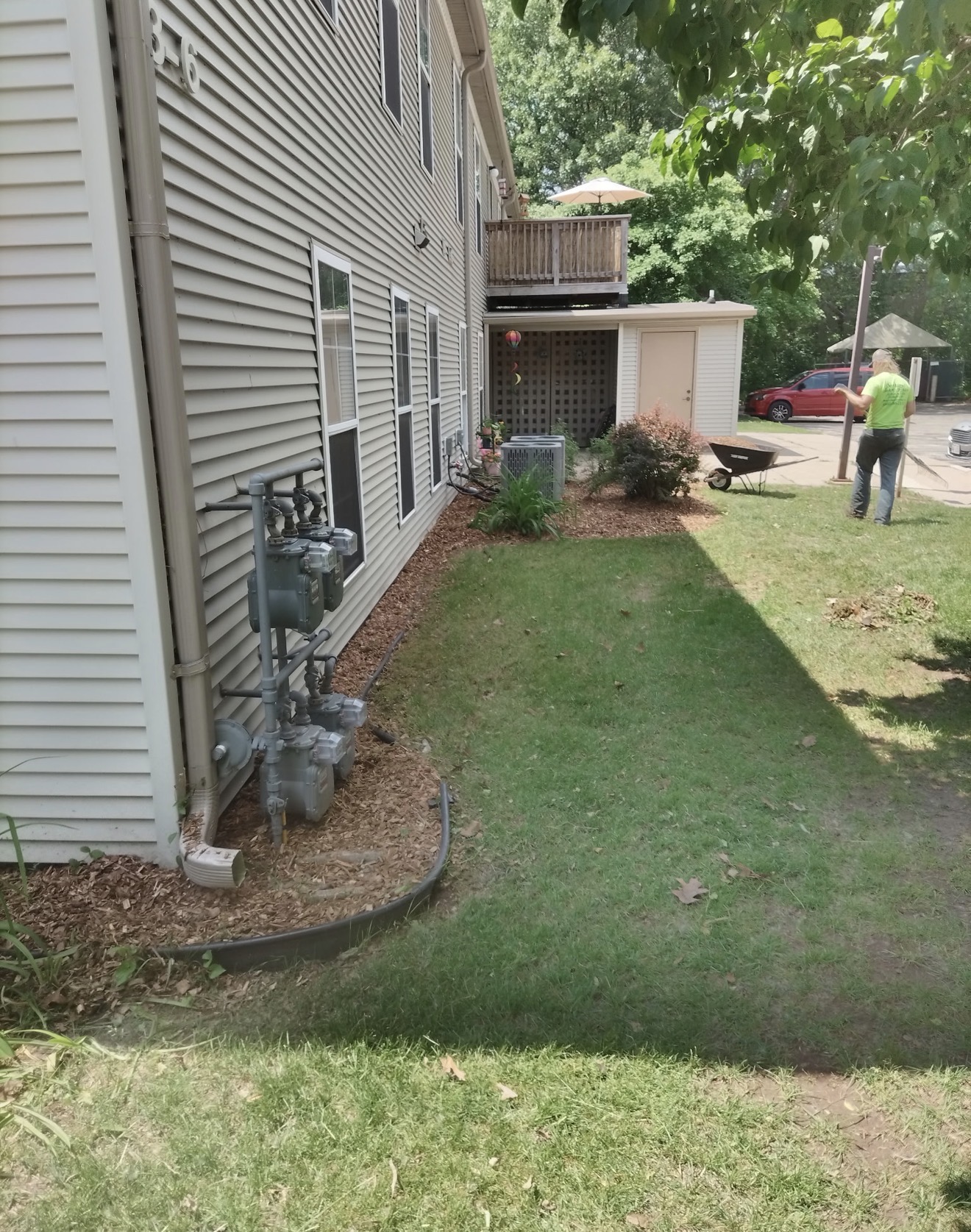 Quality Lawn Care crew member working a mulch bed